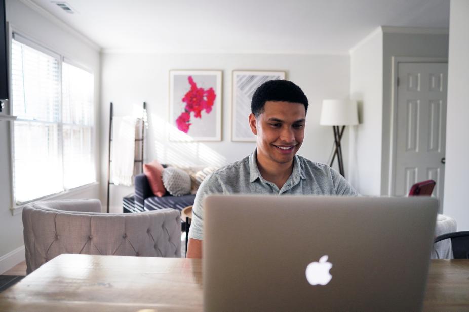 A man happily looking at his laptop