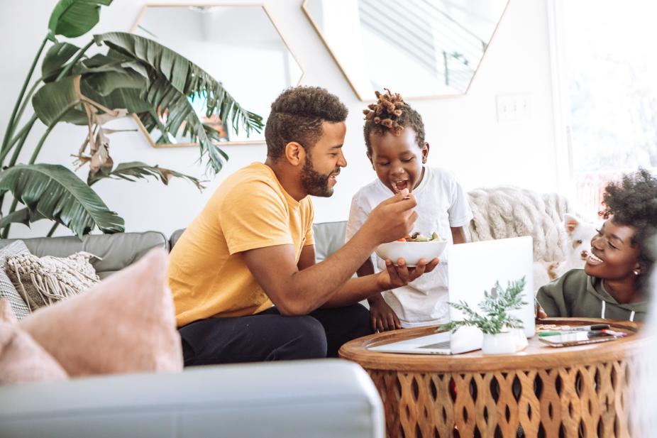 A father with his children eating in the living room