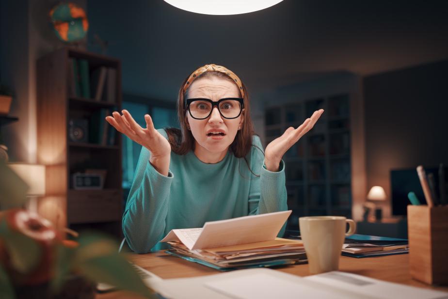 Stressed woman reviewing unpaid bills at home seeking financial assistance programs to get help paying bills